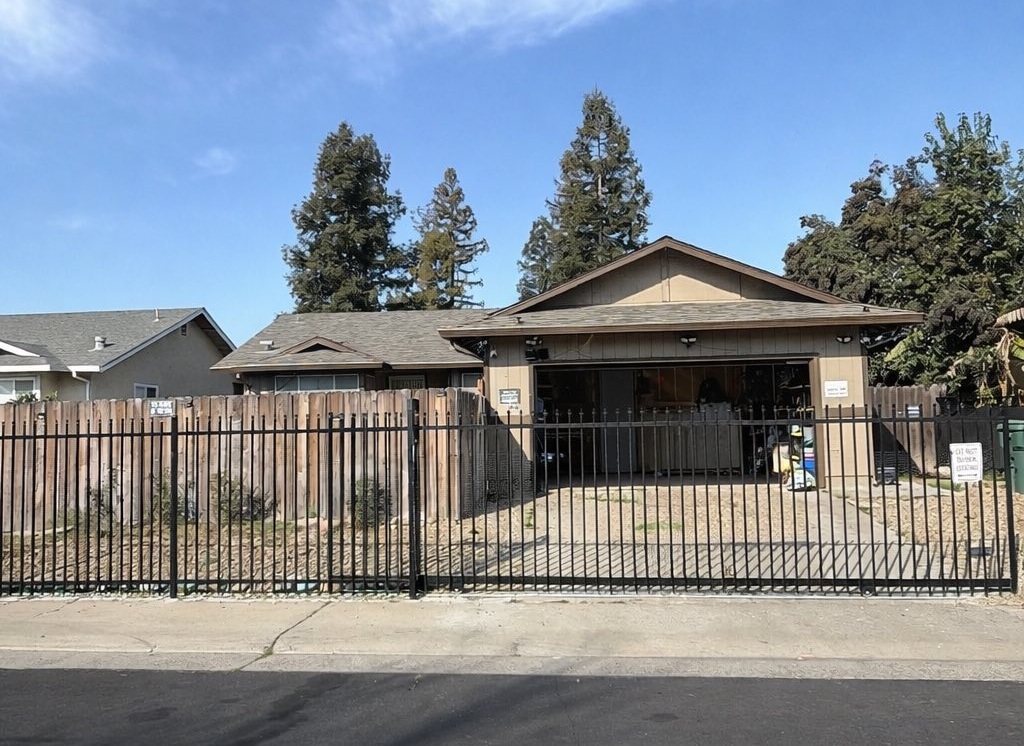 Single-story house with fenced yard and open garage driveway