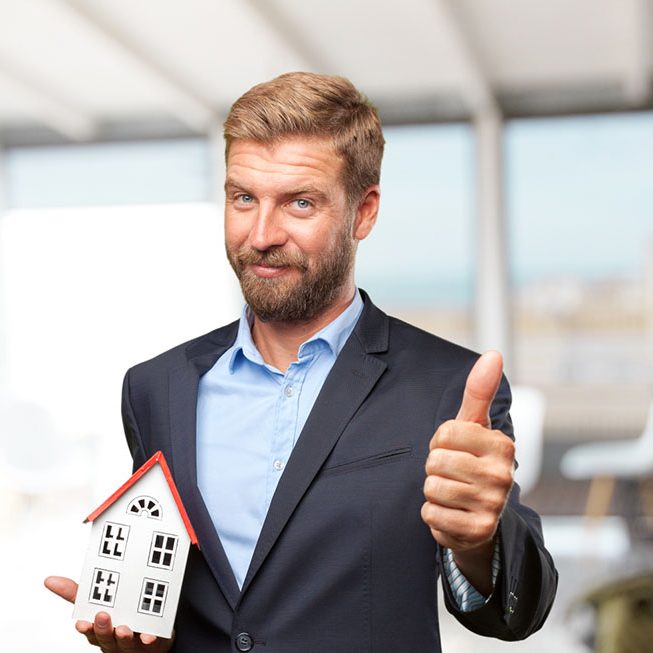 Home seller holding model house with approval sign